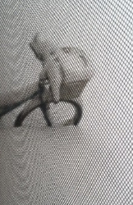 My bike out through the window with its basket full of snow.